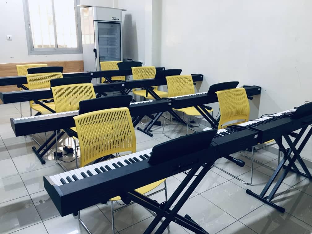 Music school classroom with yellow chairs and keyboards